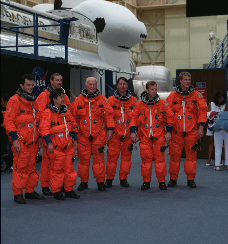 The seven crew members in training for the STS-95 mission aboard Discovery. Pictured, from the left, are Pedro Duque, Curtis Brown, Chiaki Nauto-Mukai, then-U.S. Sen. John H. Glenn Jr. (D.-Ohio), Stephen Robinson, Steven Lindsey and Scott Parazynski. (Image: NASA/JPL)